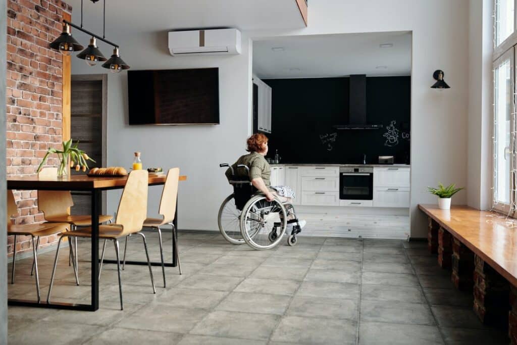 A person in a wheelchair, moving through a modern home.